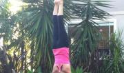 Martine Ford of Spirit Yoga practicing a handstand in the garden