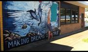 Martine Ford of Spirit Yoga practicing a handstand next to a mural