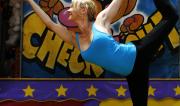 Martine Ford of Spirit Yoga in Dancers Pose holding a basket ball at the Circus.