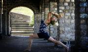 Martine Ford of Spirit Yoga in Eagle Lunge Backbend near arch staircase.