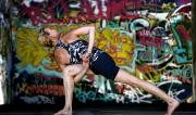 Martine Ford of Spirit Yoga in Bound Revolved Crescent Lunge amongst graffiti.