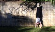 Martine Ford of Spirit Yoga practicing a handstand next to graffiti