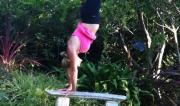 Martine Ford of Spirit Yoga practicing a handstand on a bench seat